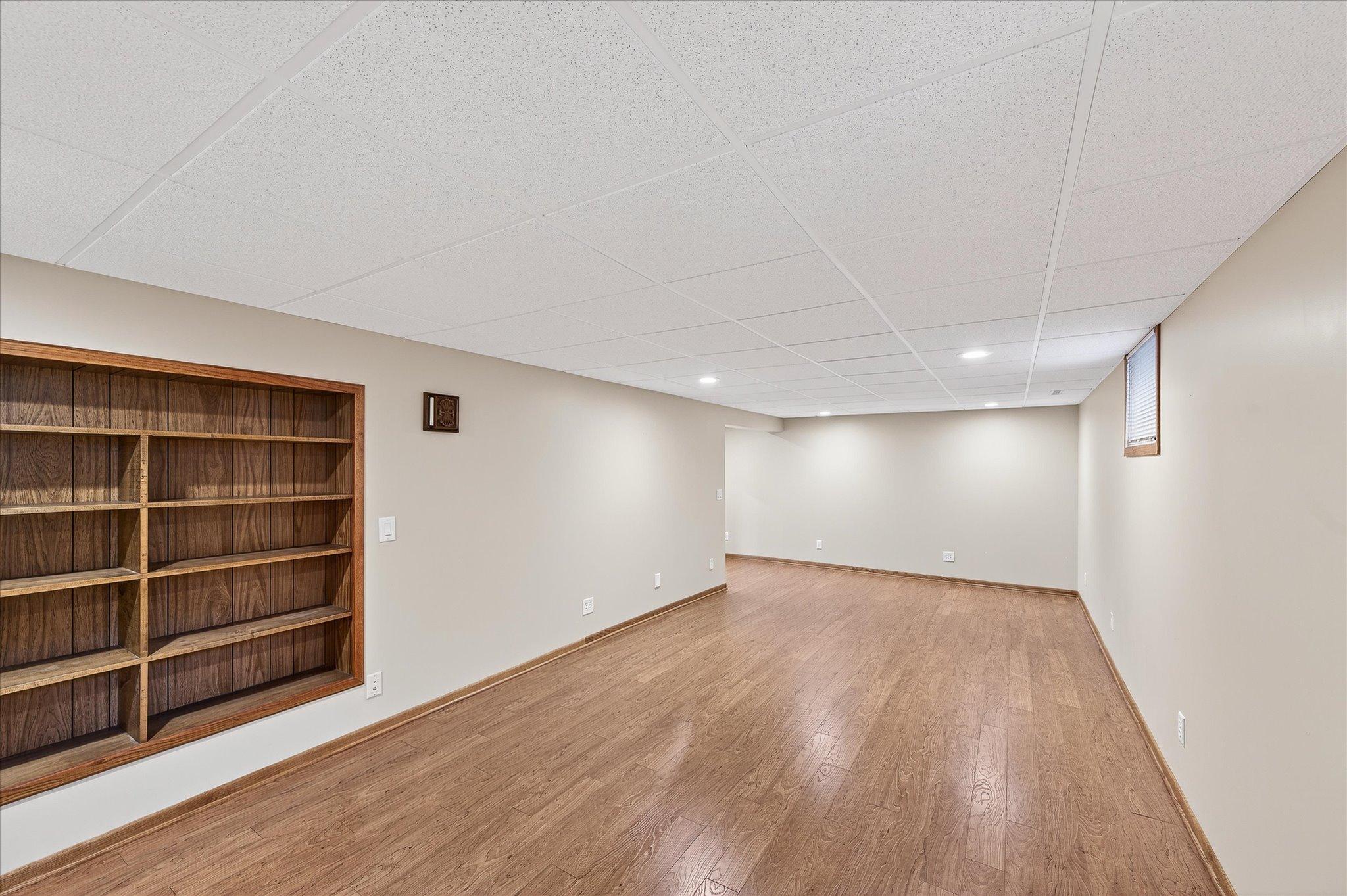 This is a flex room in the lowest level. Great for an office or play area or theater room. Built in shelves and engineered hardwood floors