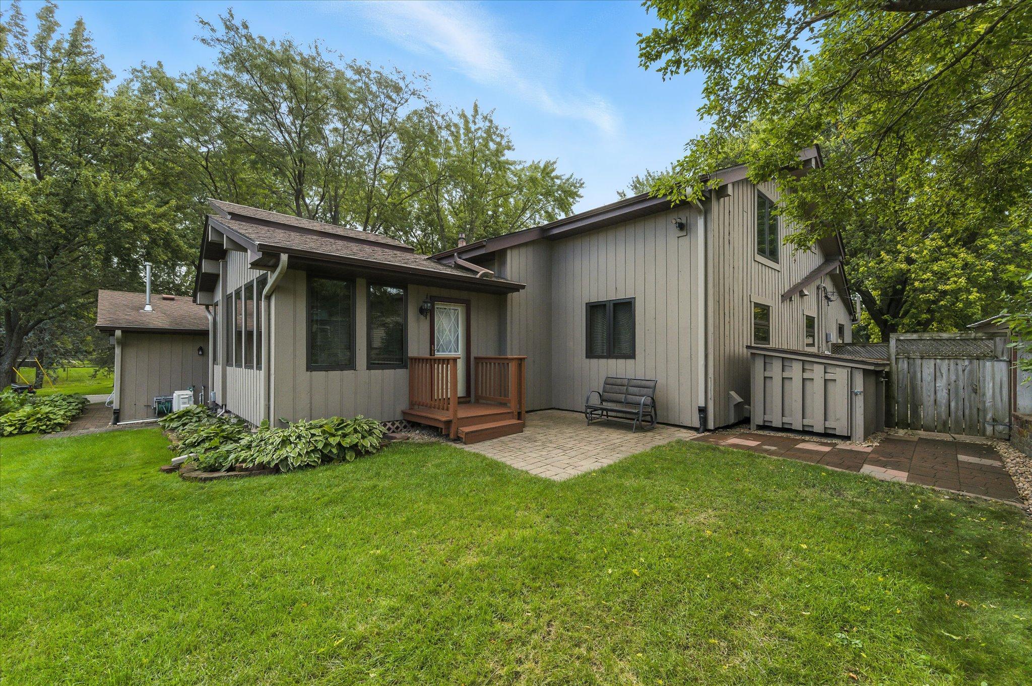 Three season porch and back paver patio leads to two sheds on the west side.