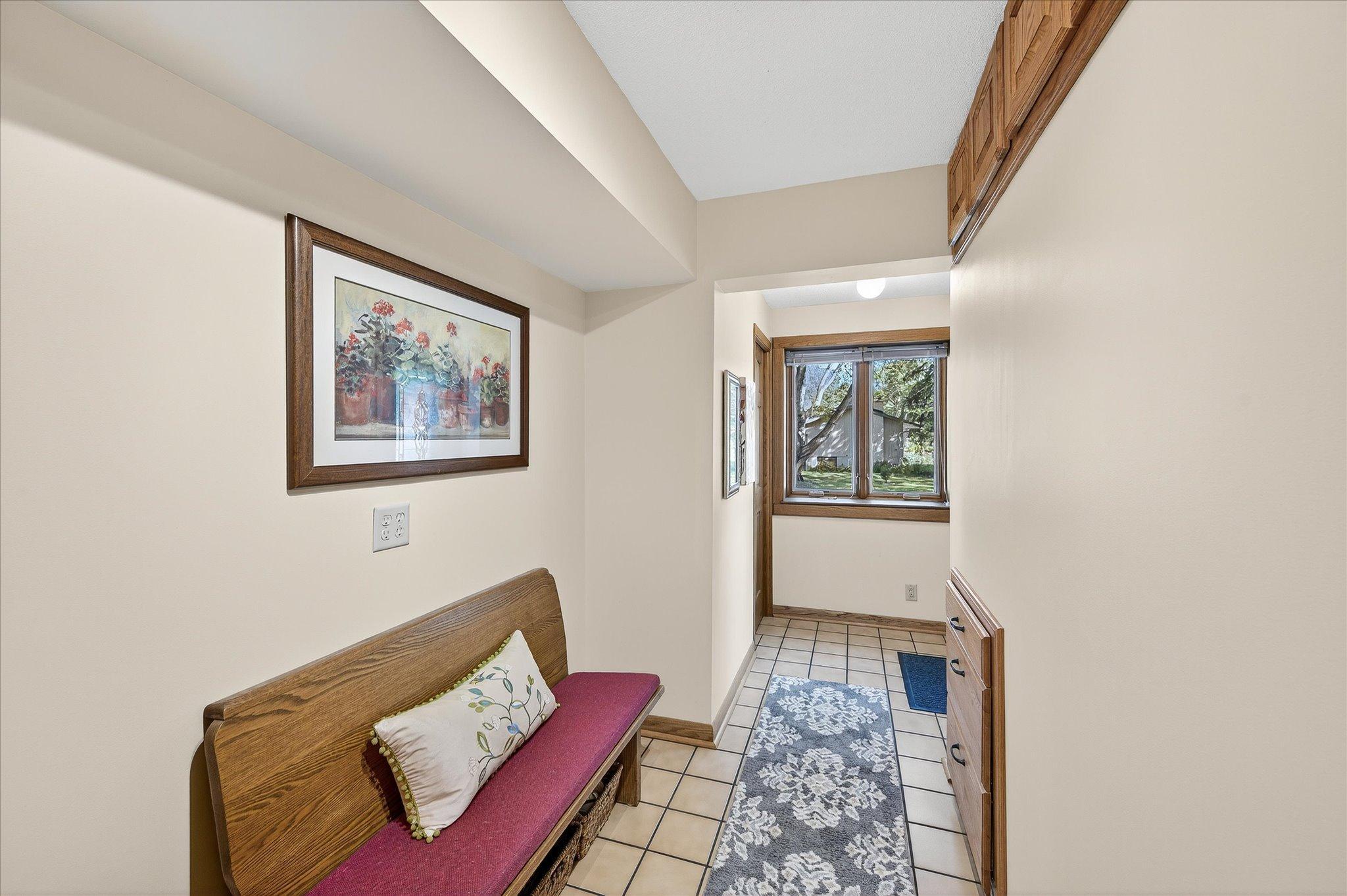 Front entry. Extra built-in cupboard above and below, coat closet by the windows. Could put in entryway cubbies.