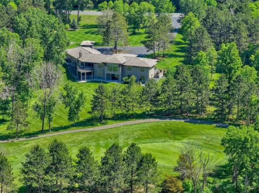 The outdoor setting offers a rare sense of space and privacy, with a sprawling yard framed by mature trees, ideal for gathering, recreation, or simply enjoying the surroundings.