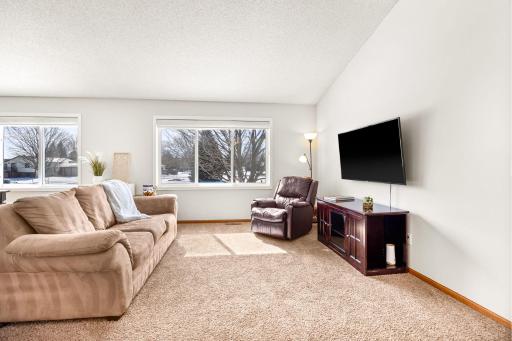 The living room and dining room windows feature custom automatic blinds.