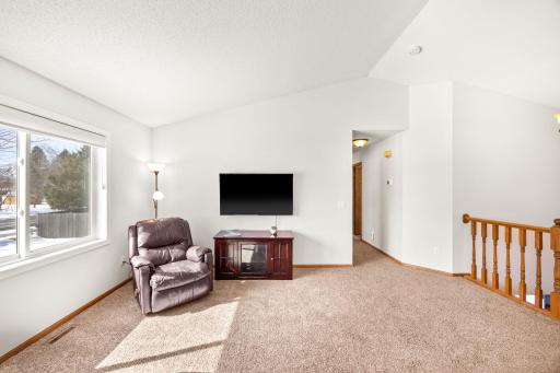The hallway off the living room leads to the bedrooms and bathroom on the upper level.