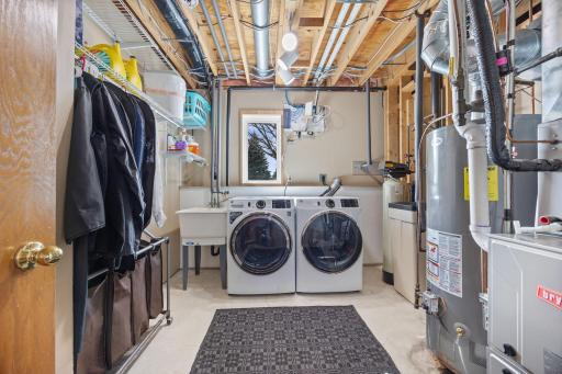 The laundry room and mechanical room in the lower level. Updated washer & dryer (2025), updated water heater (2015) & furnace & AC (2022).
