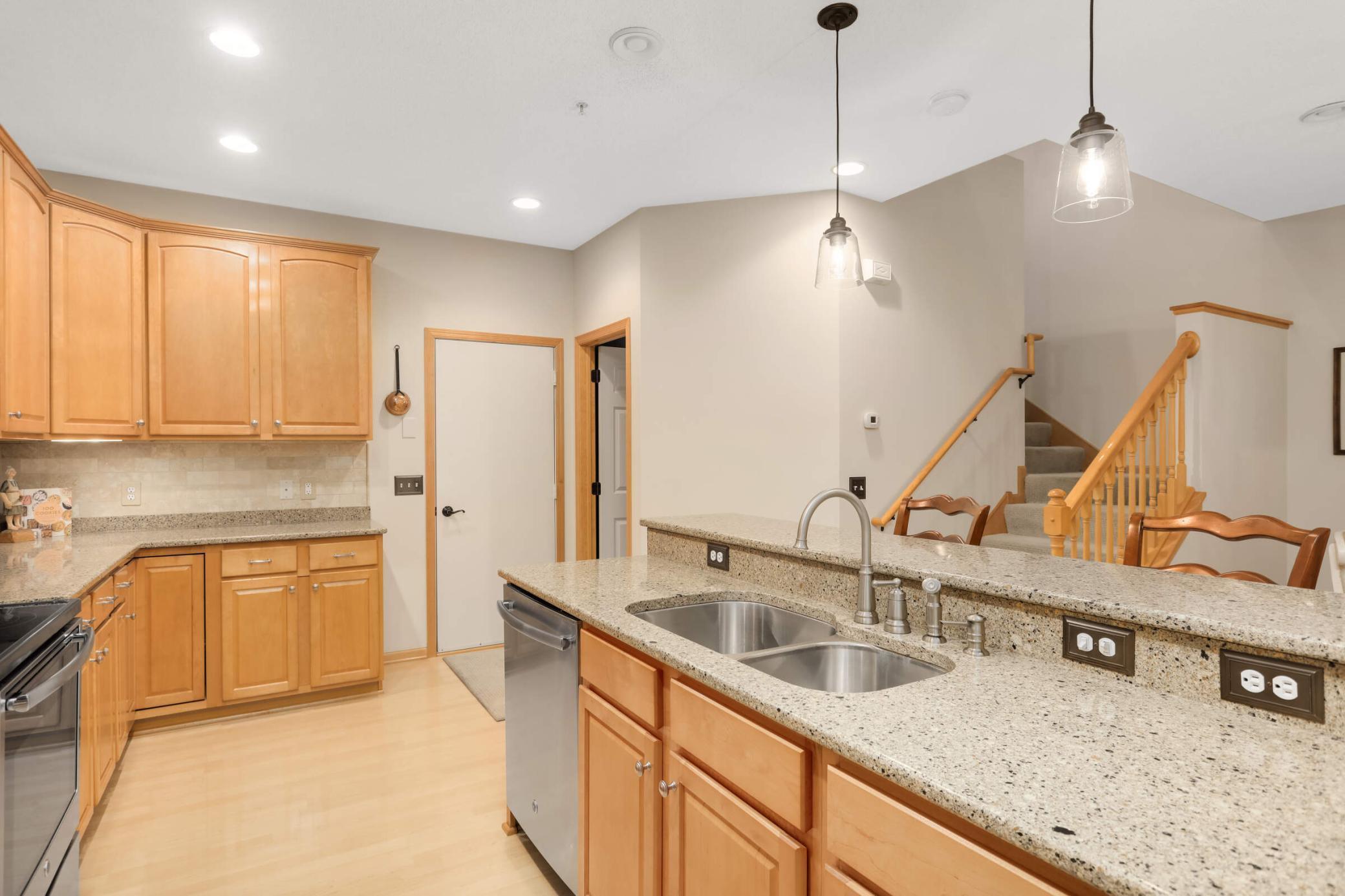 Beautifully updated with Cambria quartz countertops, on trend backsplash and under cabinet lighting, upgraded plumbing fixtures and hardware.