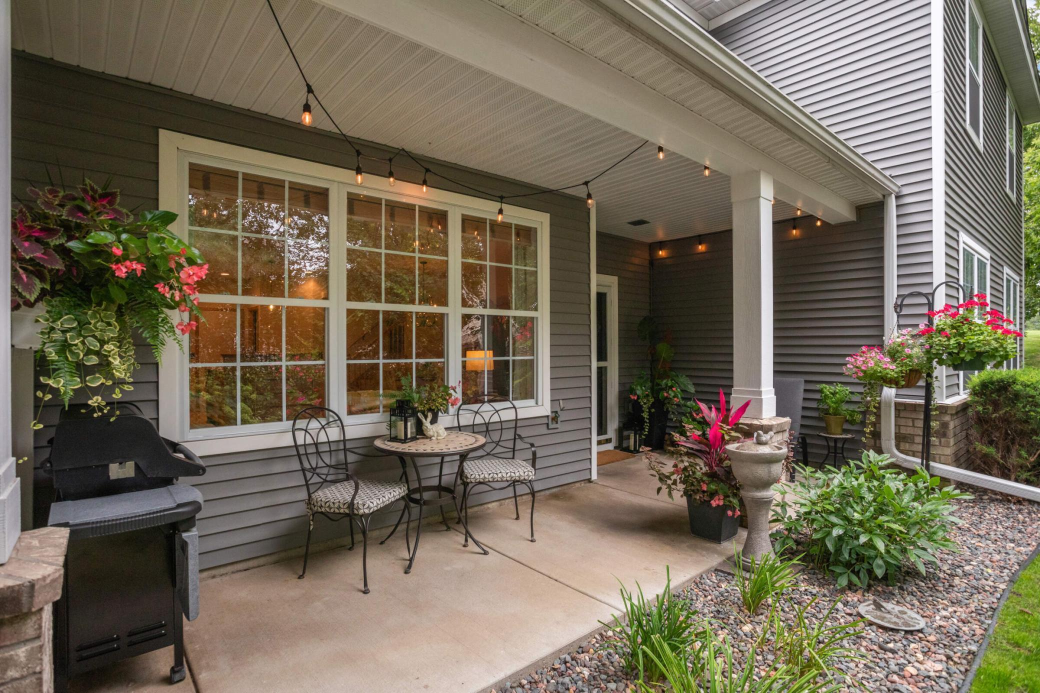 Charming covered porch overlooking a beautifully landscaped yard, creating an elevated, garden inspired ambiance.