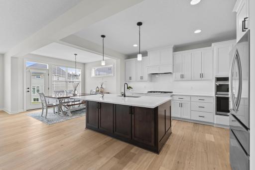 The expansive center island with natural quartz counters, a gas cooktop, double ovens & custom cabinetry.