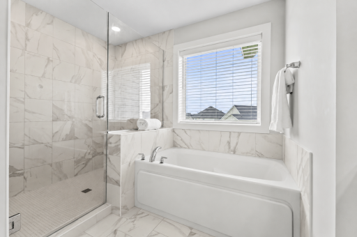 Stunning glass enclosed walk in shower with tile walls & floor. Window blinds in place for additional convenience.
