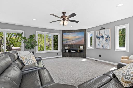 Tall windows. Lush green views. A custom feature wall with floating shelves and a mounted TV that stays. This living room has the kind of natural light that makes you feel good without knowing exactly why.