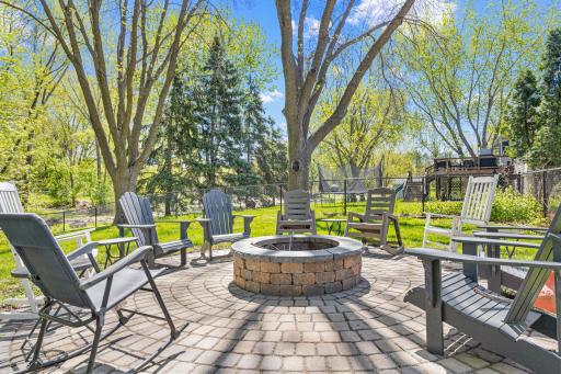 Pull up a chair. The fire pit, installed in 2021, seats a crowd, sits on a stunning paver patio, and backs up to mature trees and a gorgeous pond. Friday nights just got a serious upgrade.