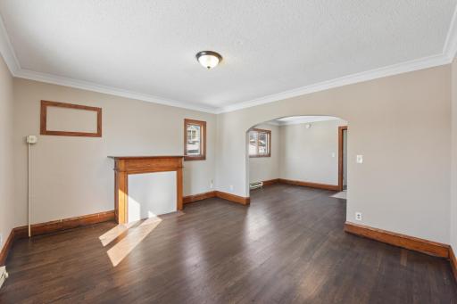 Bright and inviting living space with classic woodwork, large windows, and open flow to adjoining rooms.
