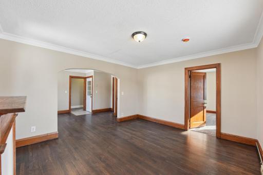 Spacious living room featuring LVP floors, arched doorway, and abundant natural light.
