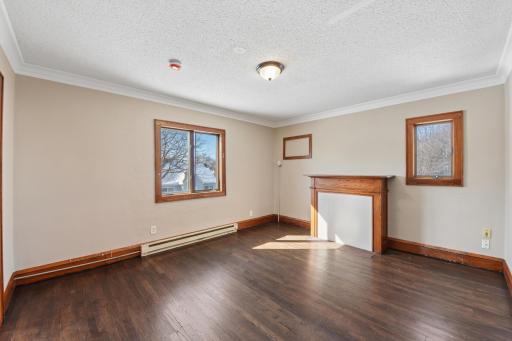 Bright and inviting living space with classic woodwork, large windows, and open flow to adjoining rooms.