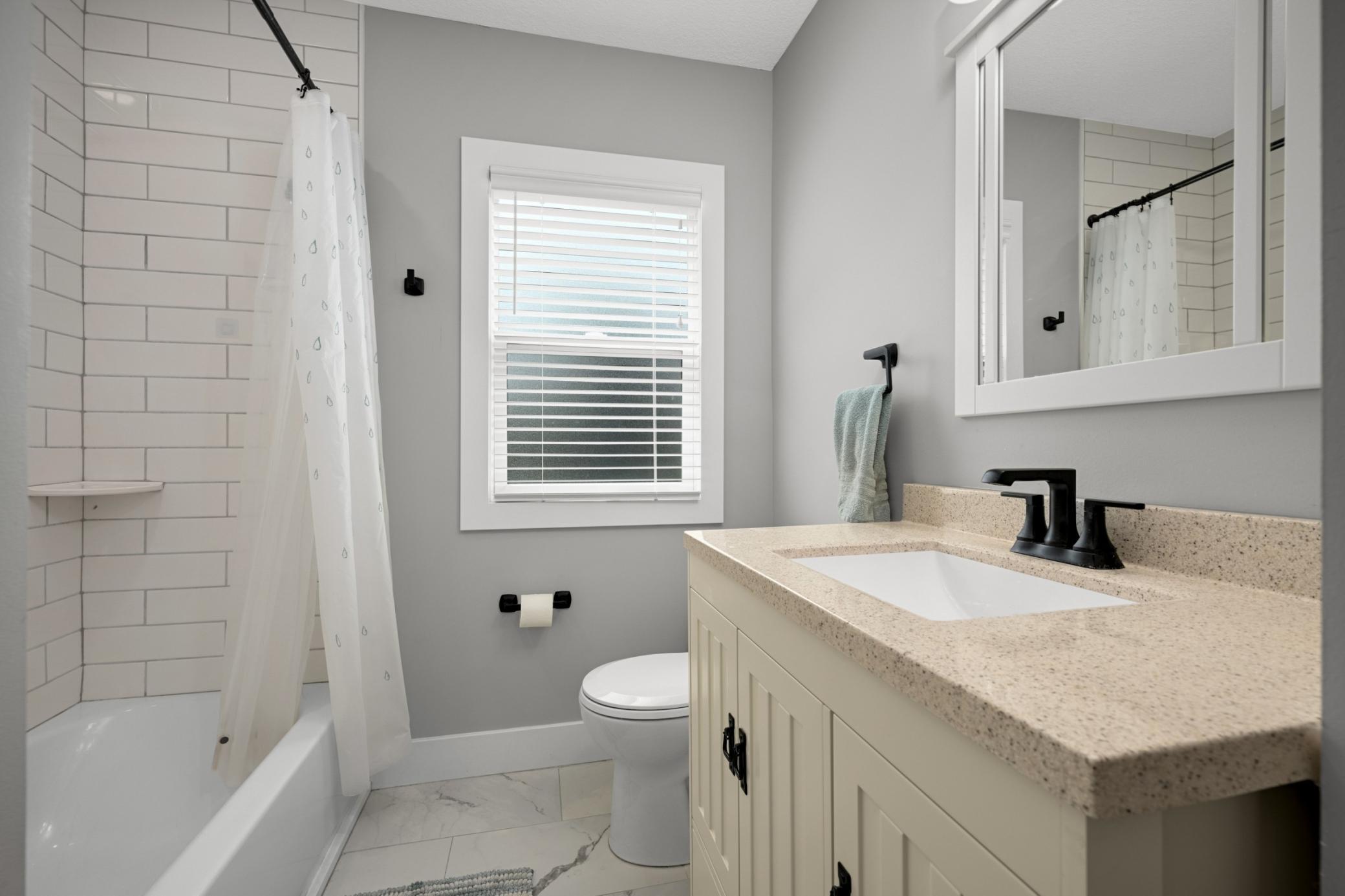 Main floor full bathroom with subway tile surround.