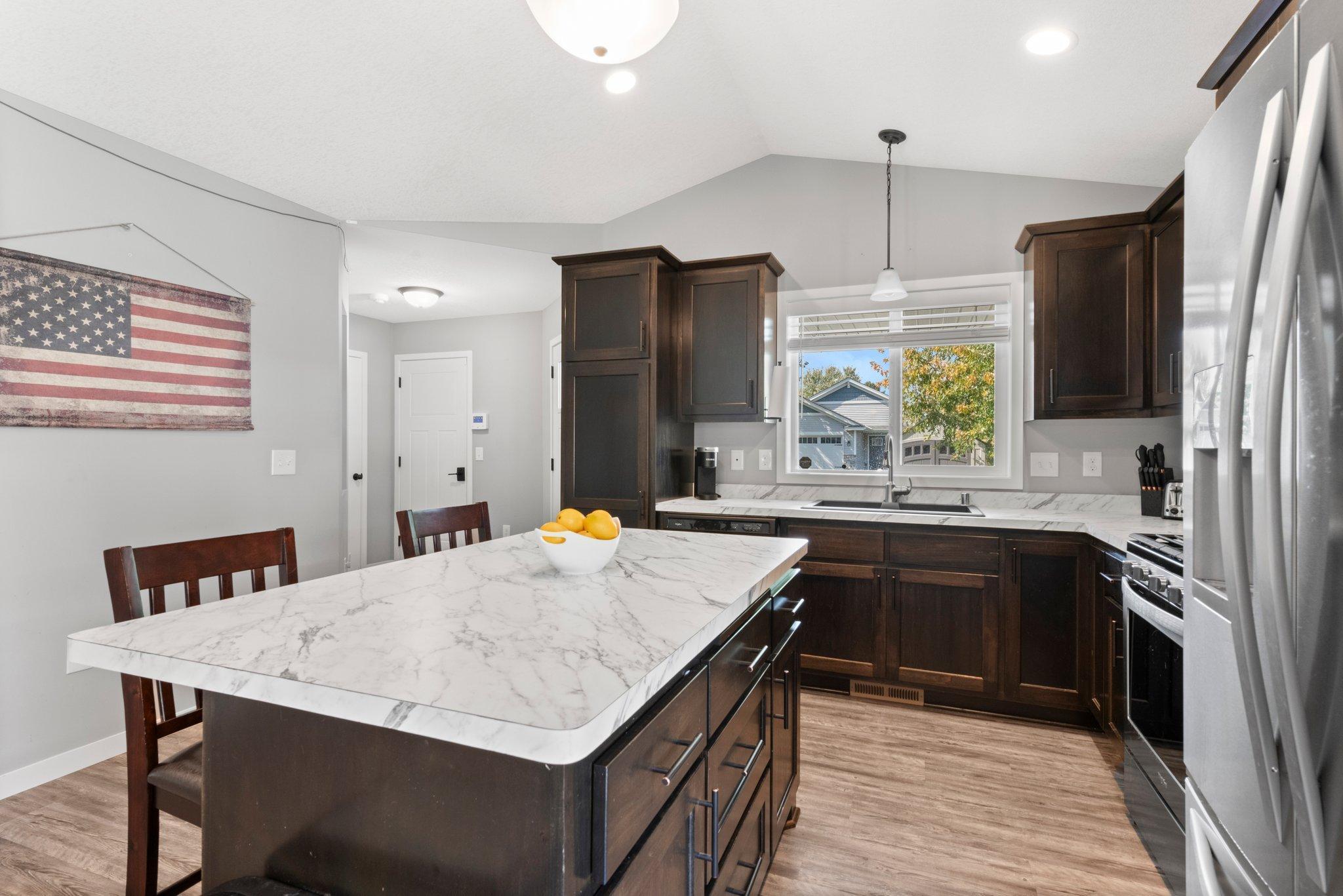 The kitchen overlooks the backyard and has storage, garage access door and a backyard door! Great layout for easy access to so much of the home.