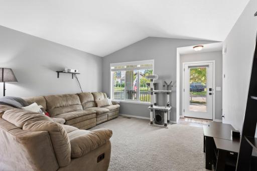 Living room has large window for great lighting, full view front door with shade and a bench to sit on as well.