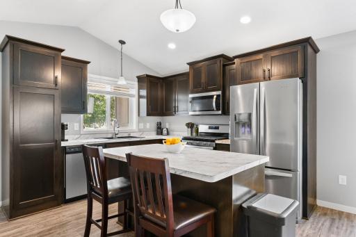 Upgraded kitchen cabinets, center island and appliances including a gas stove.