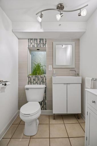 The lower-level powder room adds convenience to the private suite and adjacent space could offer potential for future expansion into a ¾ bath, adding even more versatility