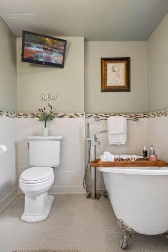A slipper-style clawfoot soaking tub adds a timeless focal point with a modern touch