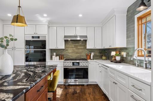 A full suite of high-end Dacor appliances anchors the space, including a 6-burner gas range and double wall oven with microwave, ready for everything from quick meals to hosting a crowd