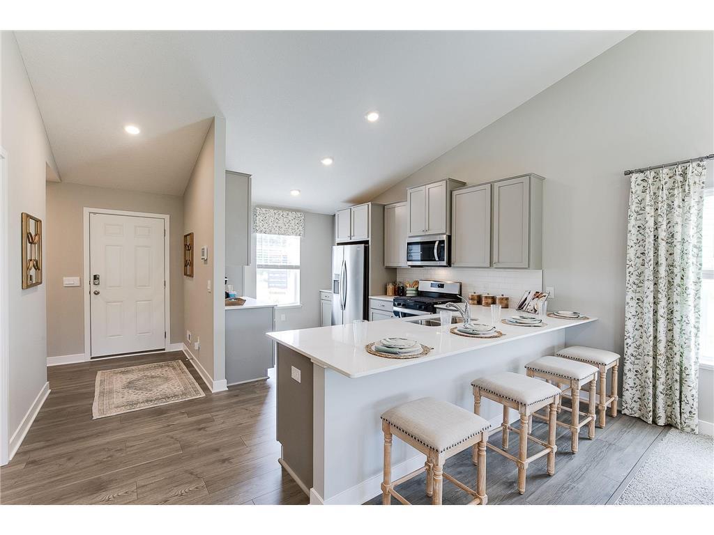 An oversized quartz peninsula allows you to stay connected with friends and family while you cook