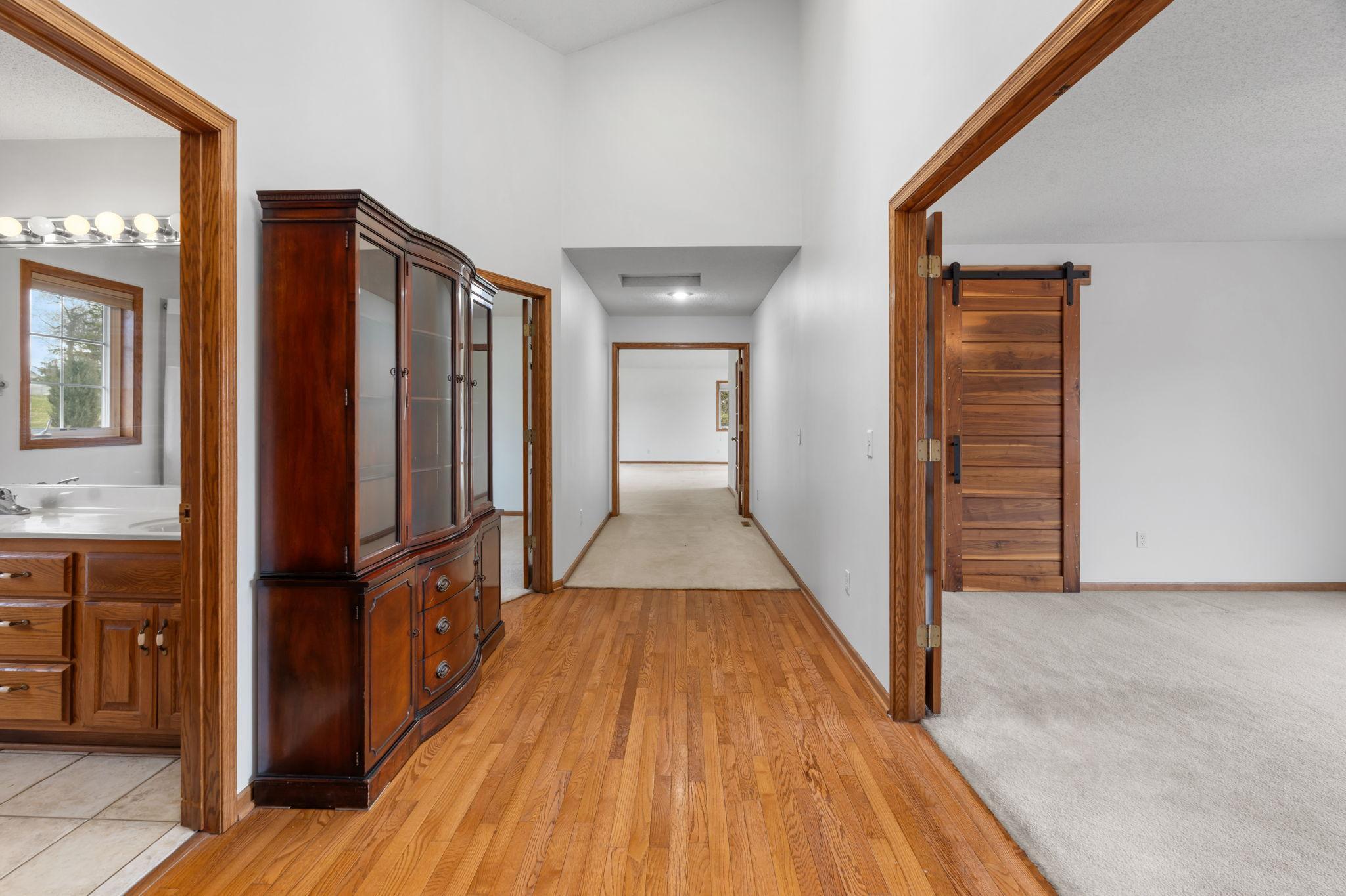 Hallway leading to primary bedroom, 2 other bedrooms and great room