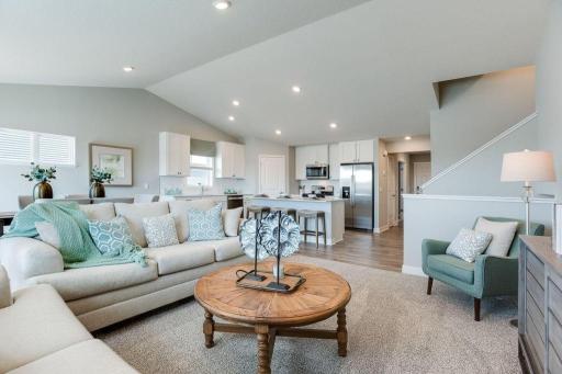 View from Living Room towards Kitchen and front entry. Photos of model home. Colors and options may vary. Ask Sales Agent for details.