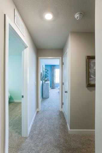 The upper-level hall to three bedrooms and two baths! Photos of model home. Colors and options may vary. Ask Sales Agent for details.