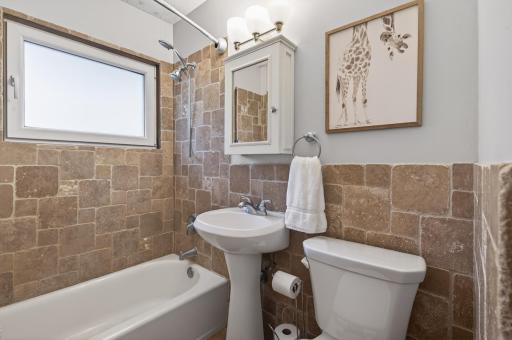Check out this tiled main floor bathroom showcasing the charm of this 1950's home!