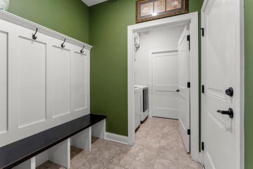 Everyday functionality is enhanced by a convenient mudroom with built-in hooks, bench seating, and cubbies, along with a finished laundry room featuring a Samsung washer and dryer and added shelving (2023).