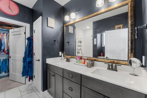 The private ensuite has heated floors, a tiled walk-in shower, double vanity, and linen storage.