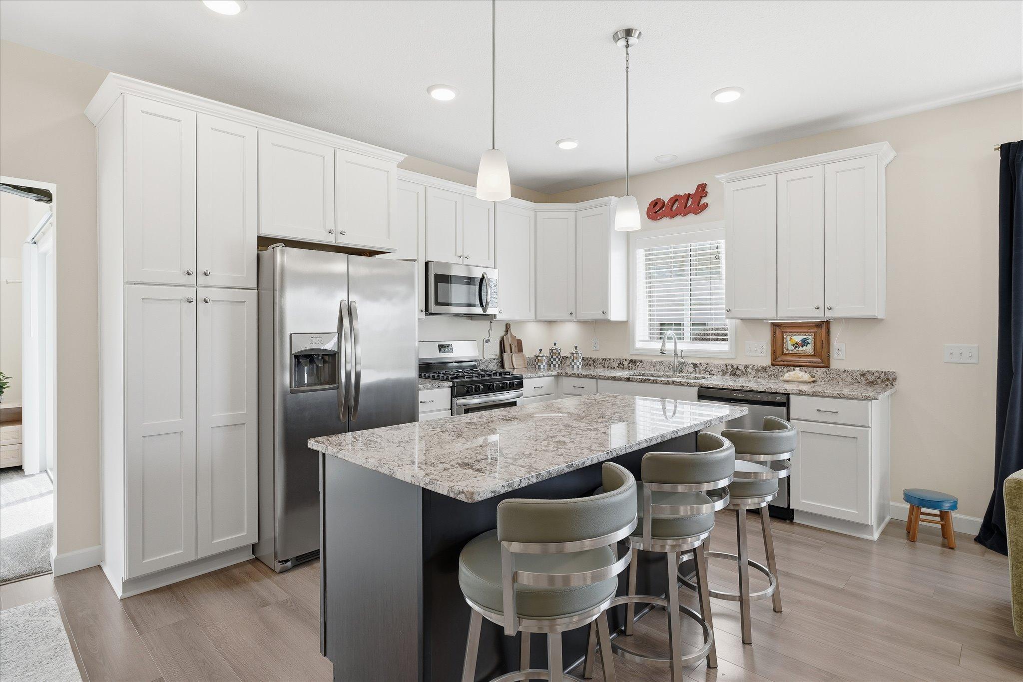 Open kitchen with maintenance free, stone countertops and soft close cabinets. A beautiful bright and open design