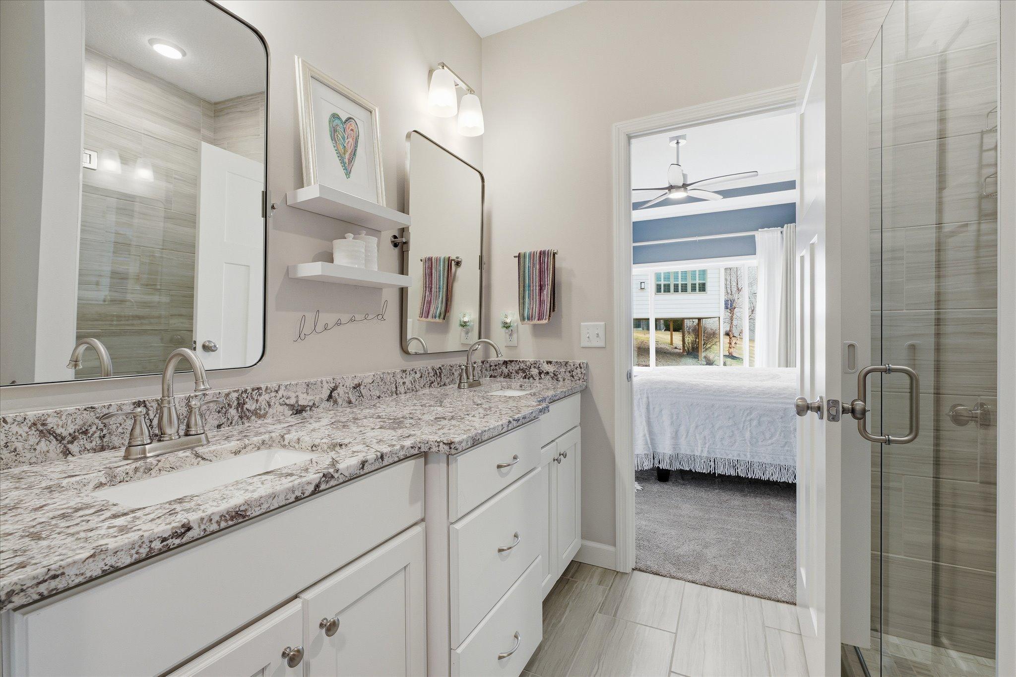 The primary ensuite offers a massive double sinks vanity with tiled floors and curbless shower.