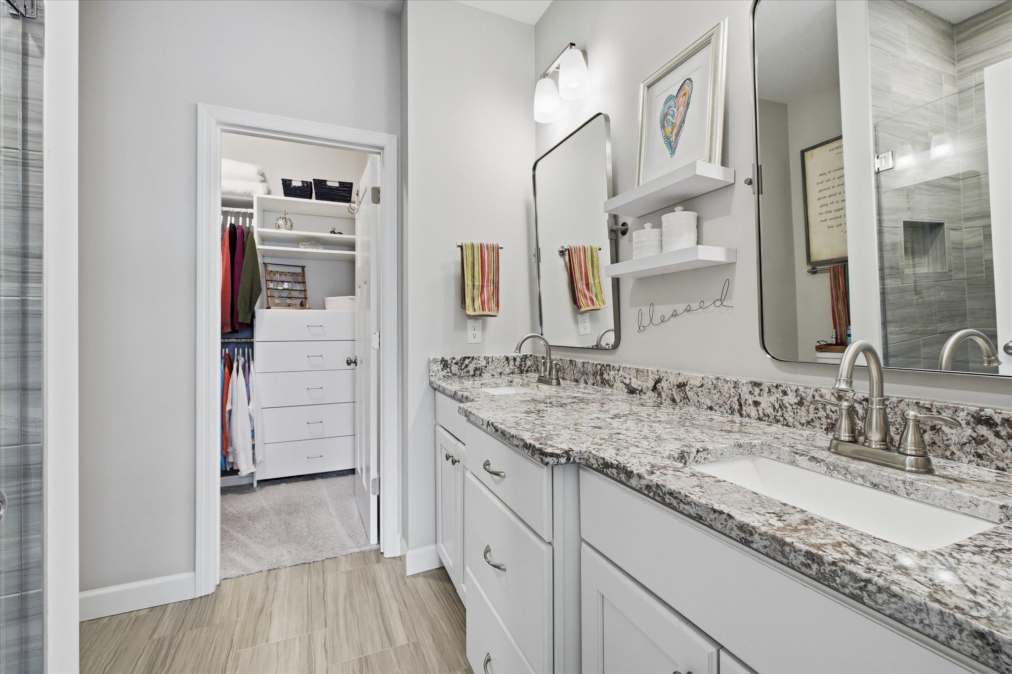 The primary ensuite offers a massive double sinks vanity with tiled floors and curbless shower - plus the to-die-for walkin closet with built-ins.
