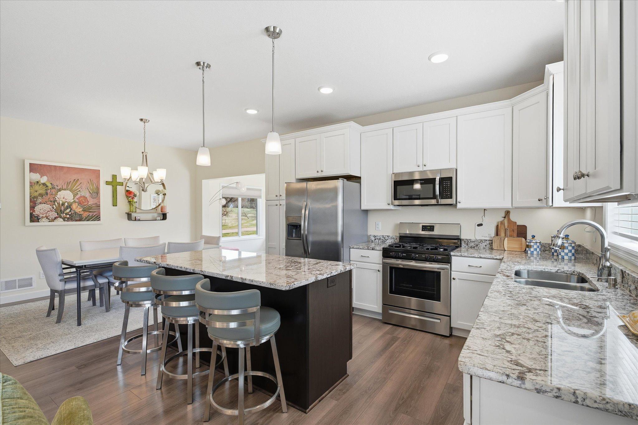 Open kitchen with maintenance free, stone countertops and soft close cabinets. A beautiful bright and open design
