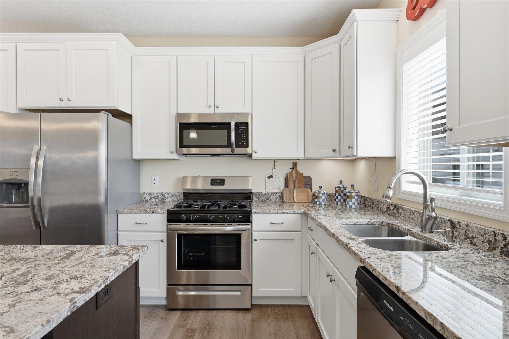 Open kitchen with maintenance free, stone countertops and soft close cabinets. A beautiful bright and open design