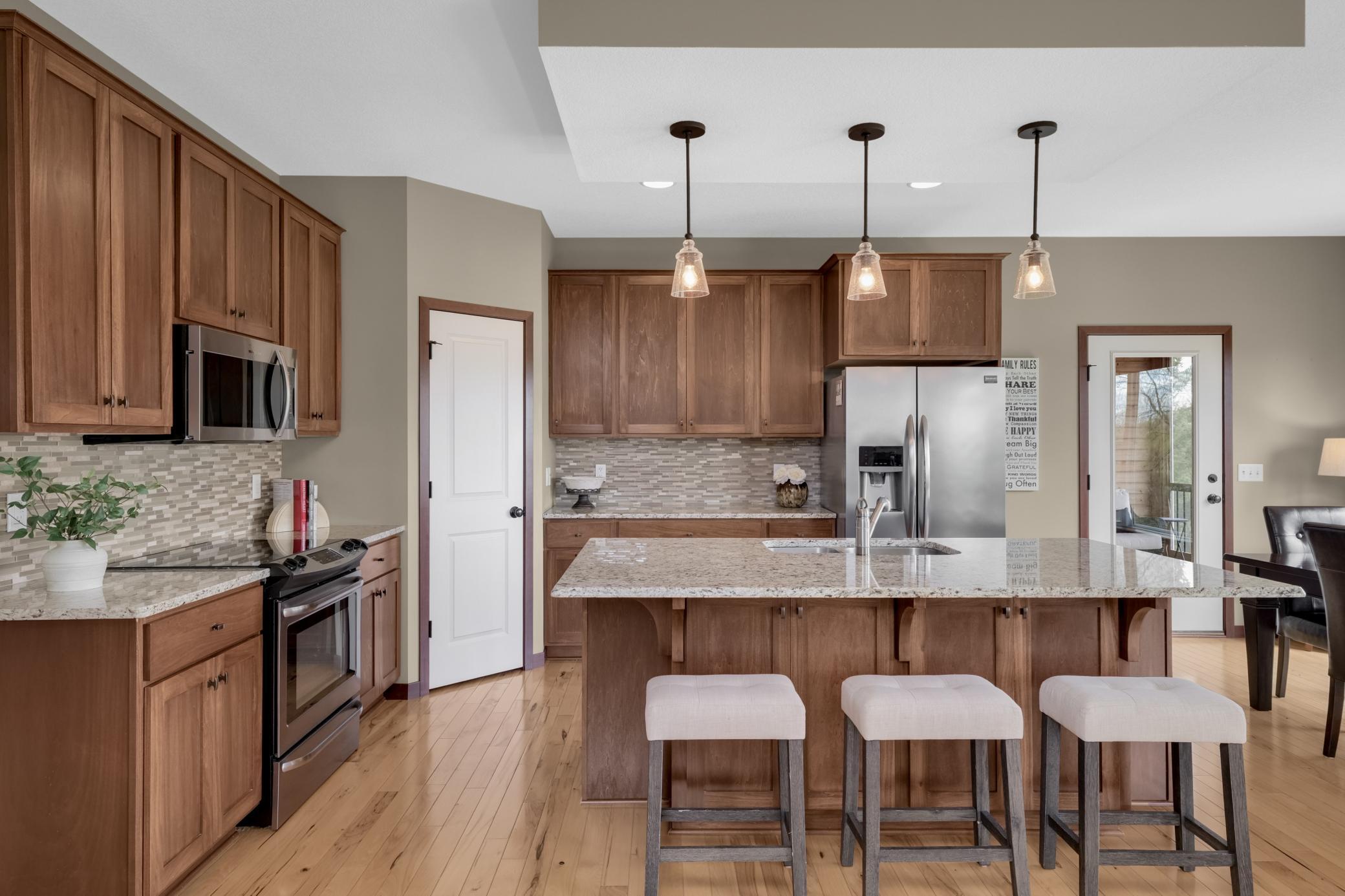 Featuring a convenient center island with sink, offering additional seating, prep space, and perfect flow for entertaining.