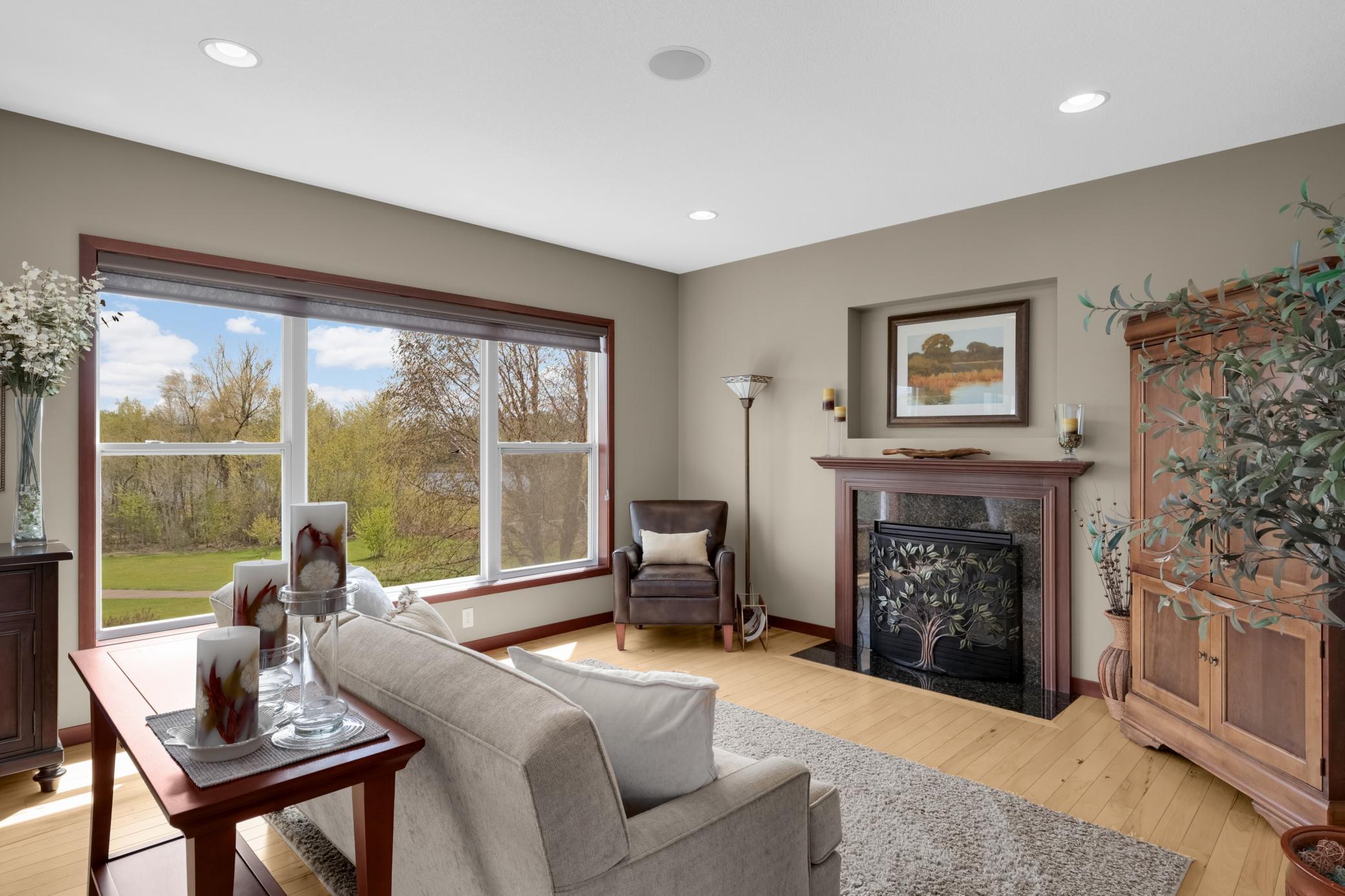 Warm and inviting south-facing living room highlighted by a gas fireplace, integrated speaker system, and recessed lighting.