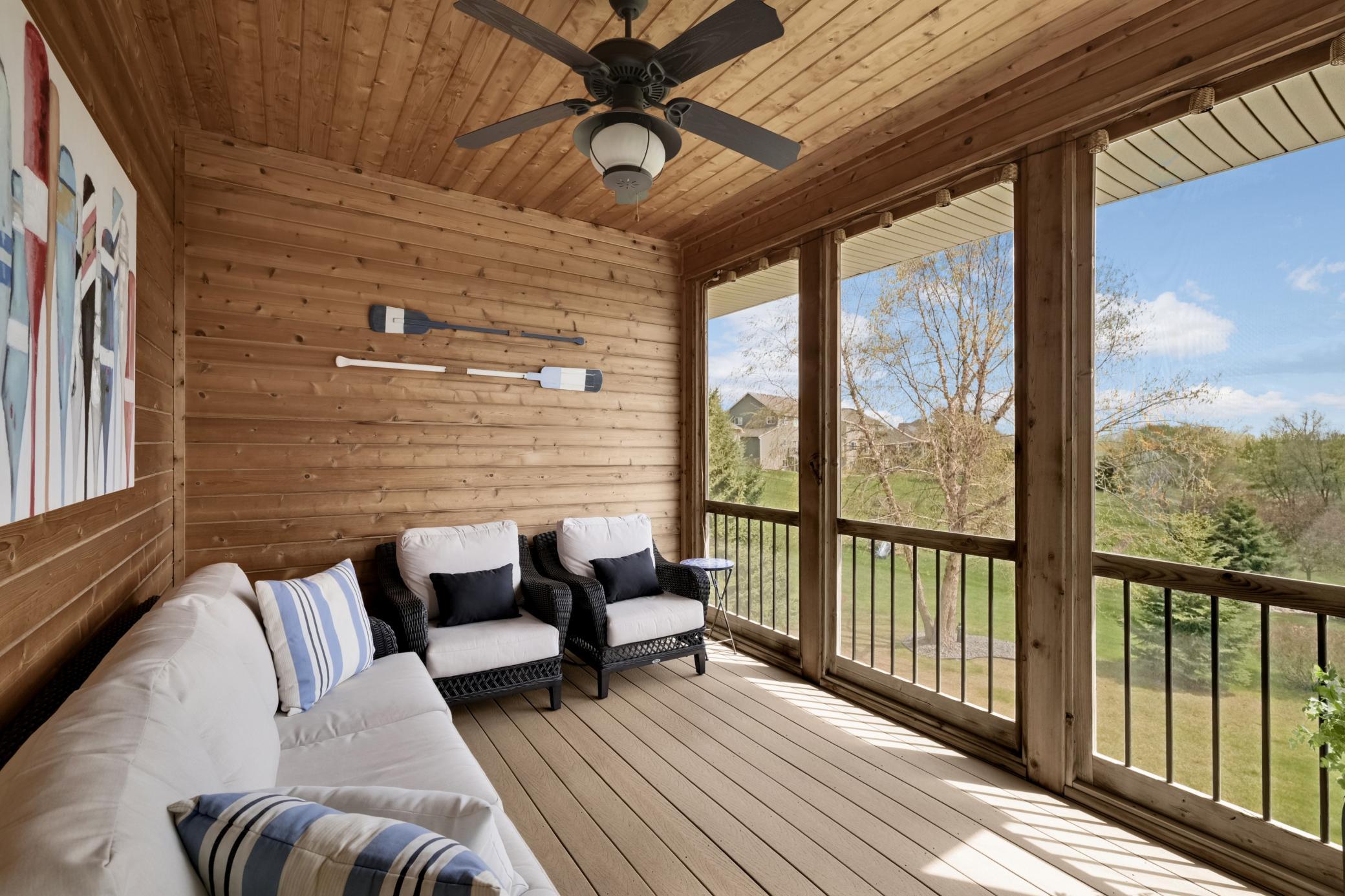 Picture yourself relaxing on the covered and screened three-season porch with wood accents and maintenance-free decking, taking in peaceful, open views.