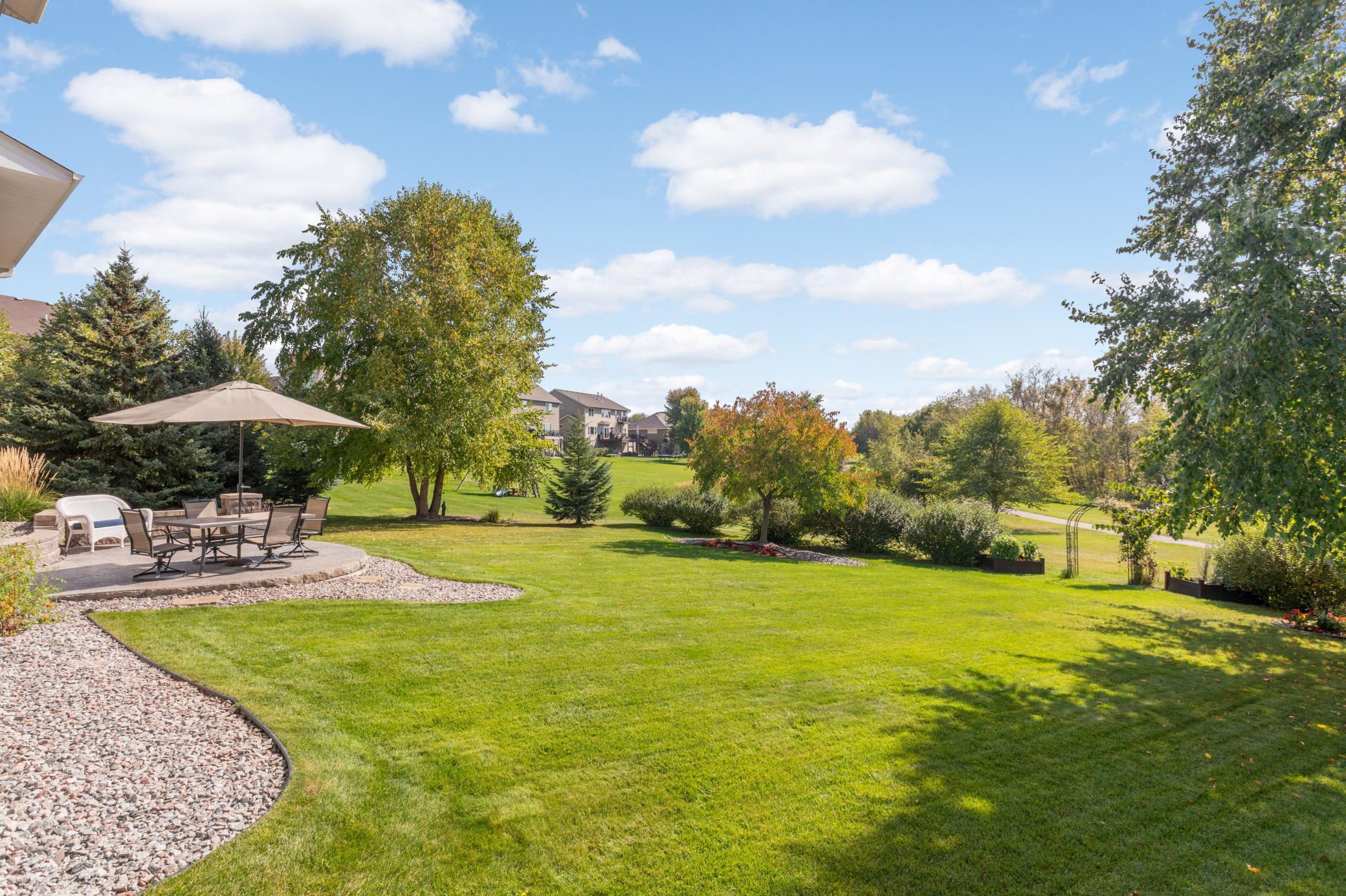 Peaceful views await right outside your back door with inviting patio living, professional landscaping, and an expansive stamped concrete patio.