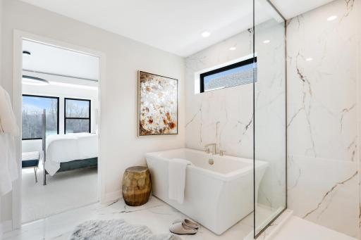 Primary bedroom ensuite with walk-in tile shower, freestanding soaker tub and dual vanities *Photo of similar home