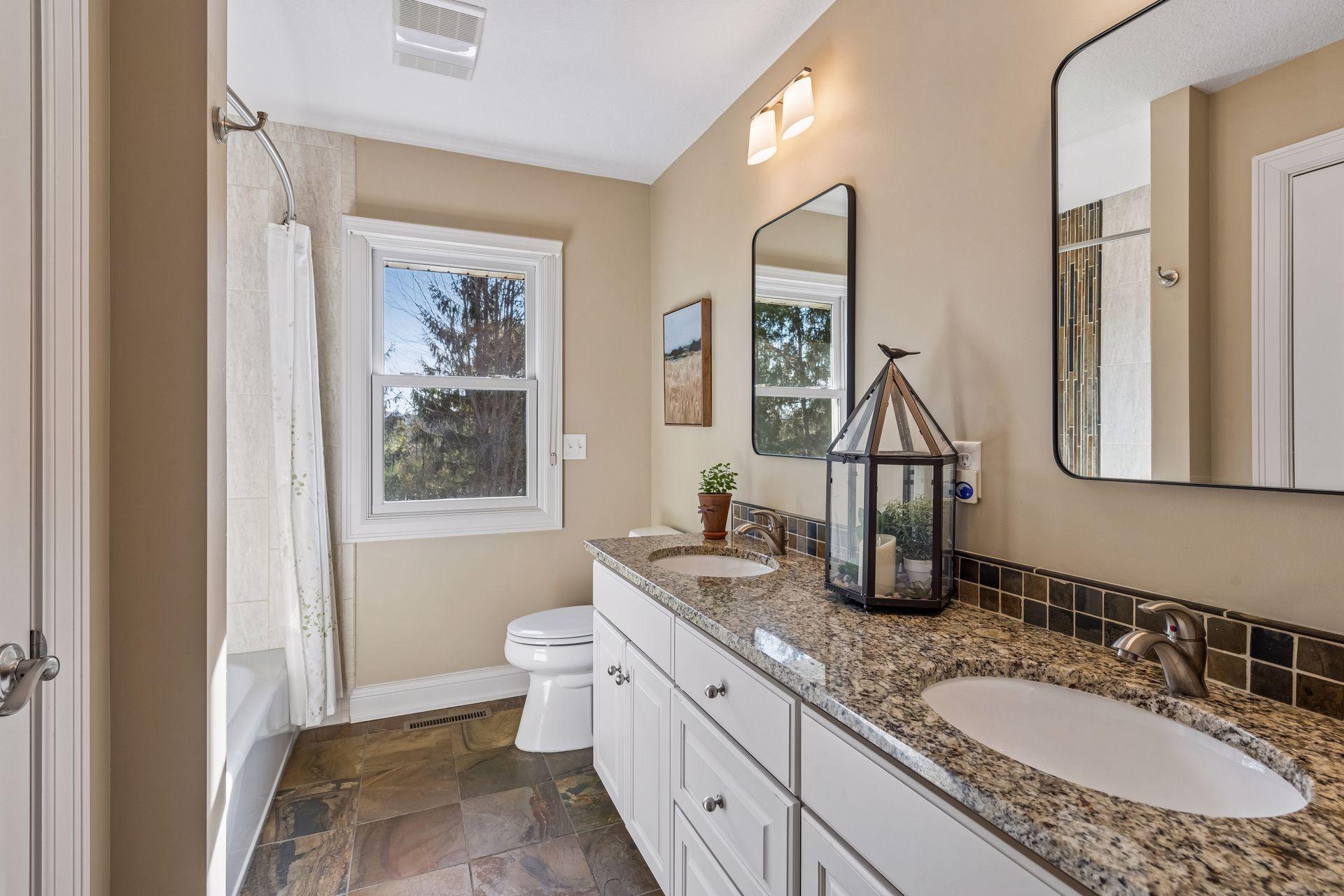 Main level full bathroom, granite countertops, undermount sinks, tile flooring, storage closet, shower. 7'7"X10'10"