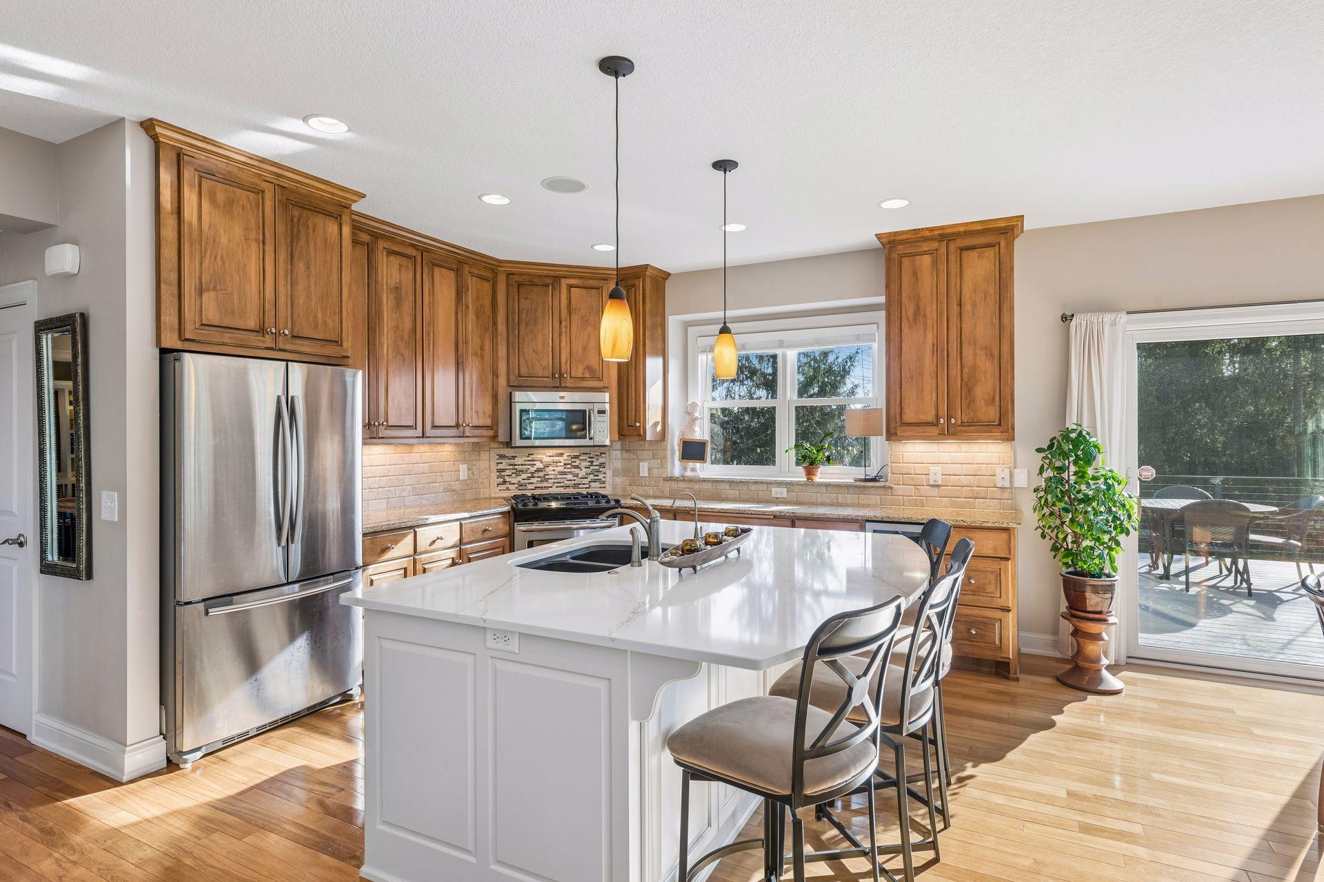 Beautiful, light filled kitchen, features a quartz countertop on the center island, maple cabinets, stainless steel appliances, backsplash, granite countertops, walk-in pantry, hardwood floors. Kitchen flows to informal dining area and living room.