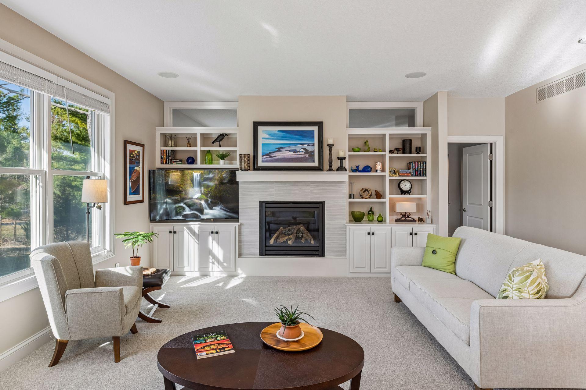 Stunning, light filled, main floor living room. Features gas fireplace with tile surround, built-in cabinets, and shelves. Please note the 2 clerestory windows, above the shelves, which bring in natural light to the adjacent primary en-suite.