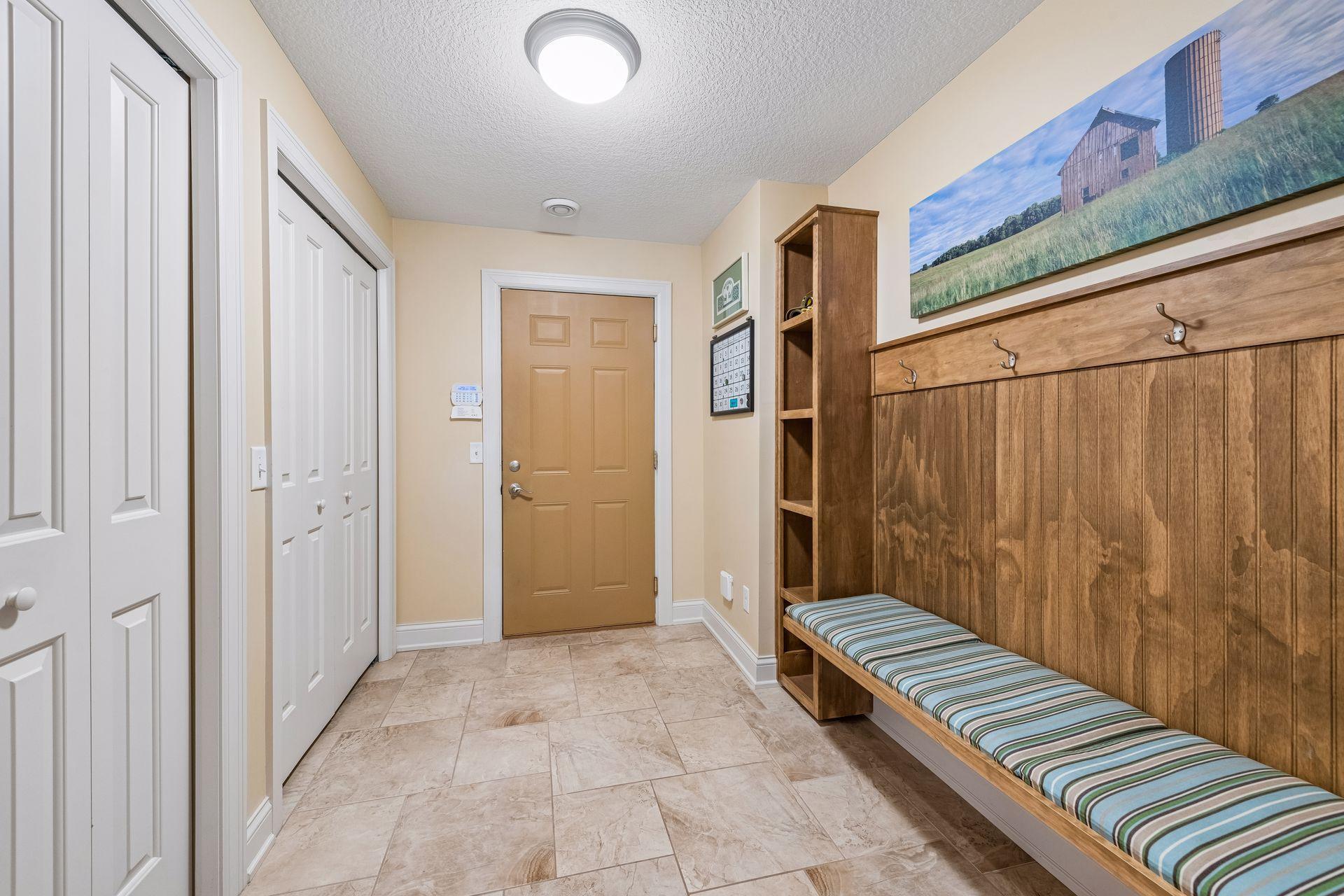 The lower-level mud room, adjacent to the garage, has it all! Custom bench, wainscoting, hooks, shelves for keys, phones, tile flooring, 2 closets with storage systems for coats and shoes. Updated security system- Bravas (owned)