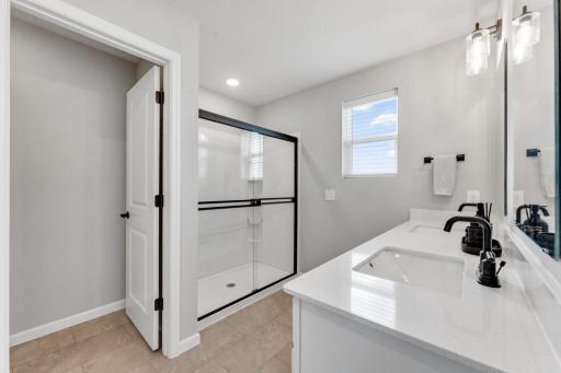 Private primary with dual sinks, shower and separate toilet room