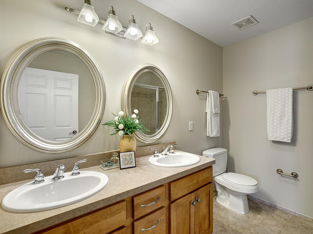 Dual sink vanity and tiled floors in primary bath