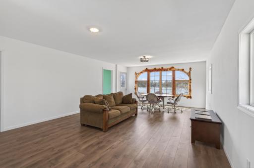 Bonus living space above the garage with beautiful LVT and a view of the lake. This finished space is not added to finished living space on the listing. Add heat and plumbing to make it the perfect guest suite!
