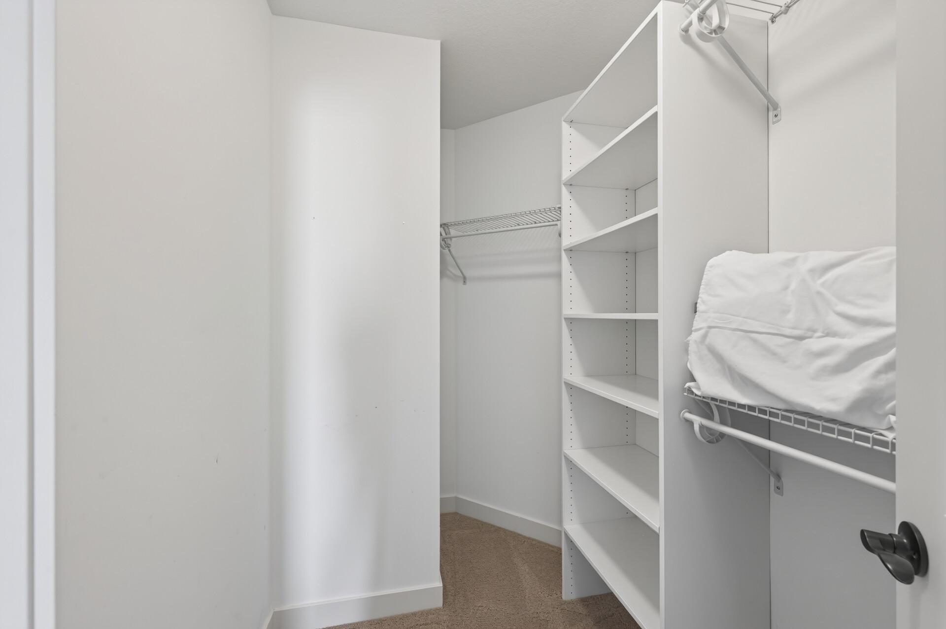 Custom shelving keeps the walk-in closet organized and functional.