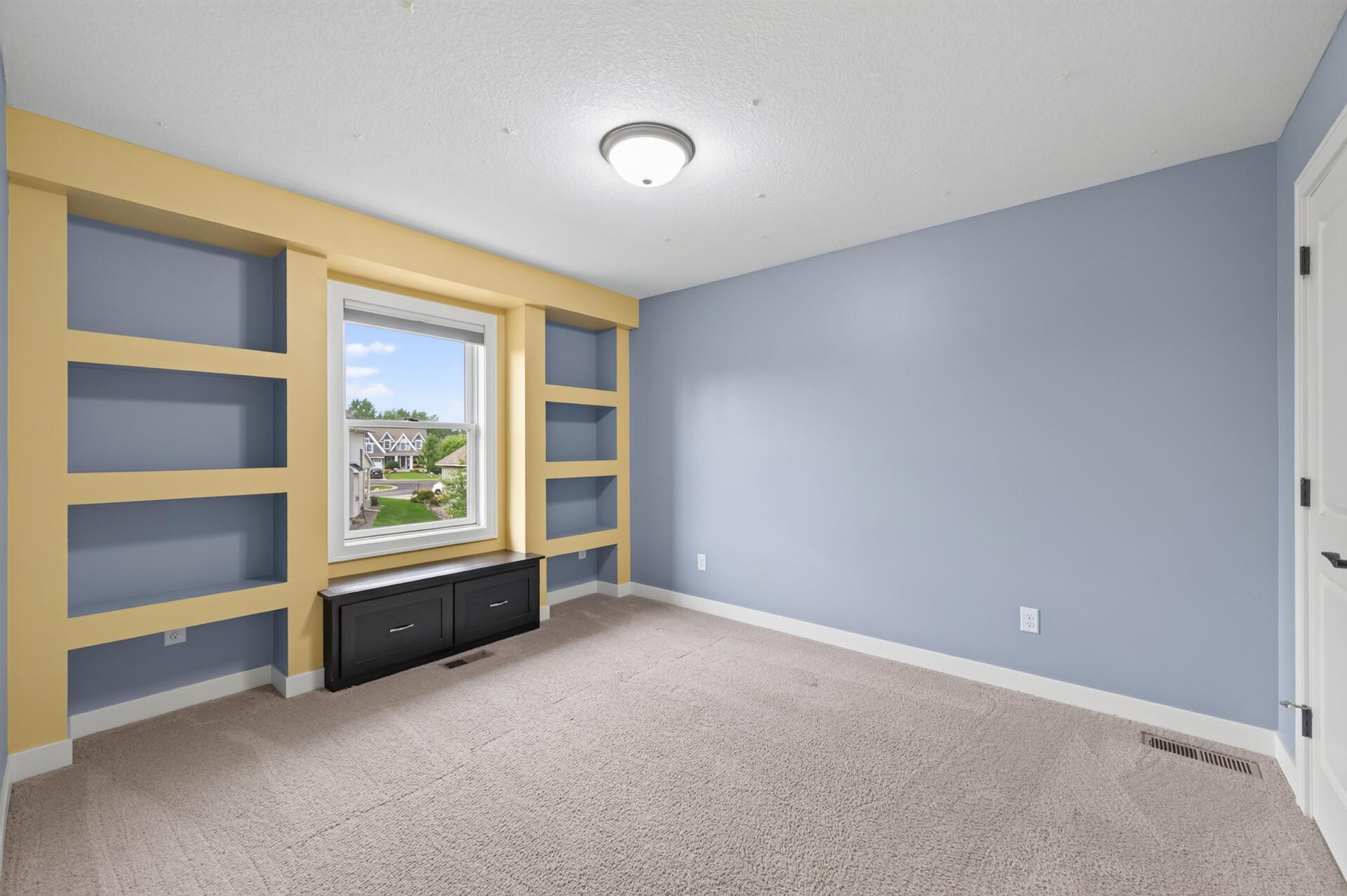 Built-in shelving adds charm and functionality to this spacious bedroom.