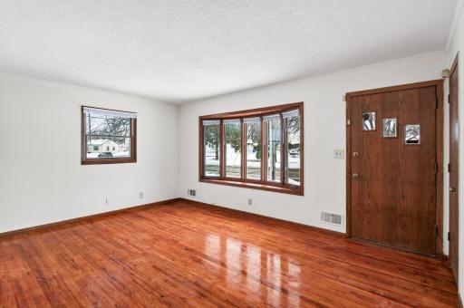 Living room with bow window and hardwood floors.